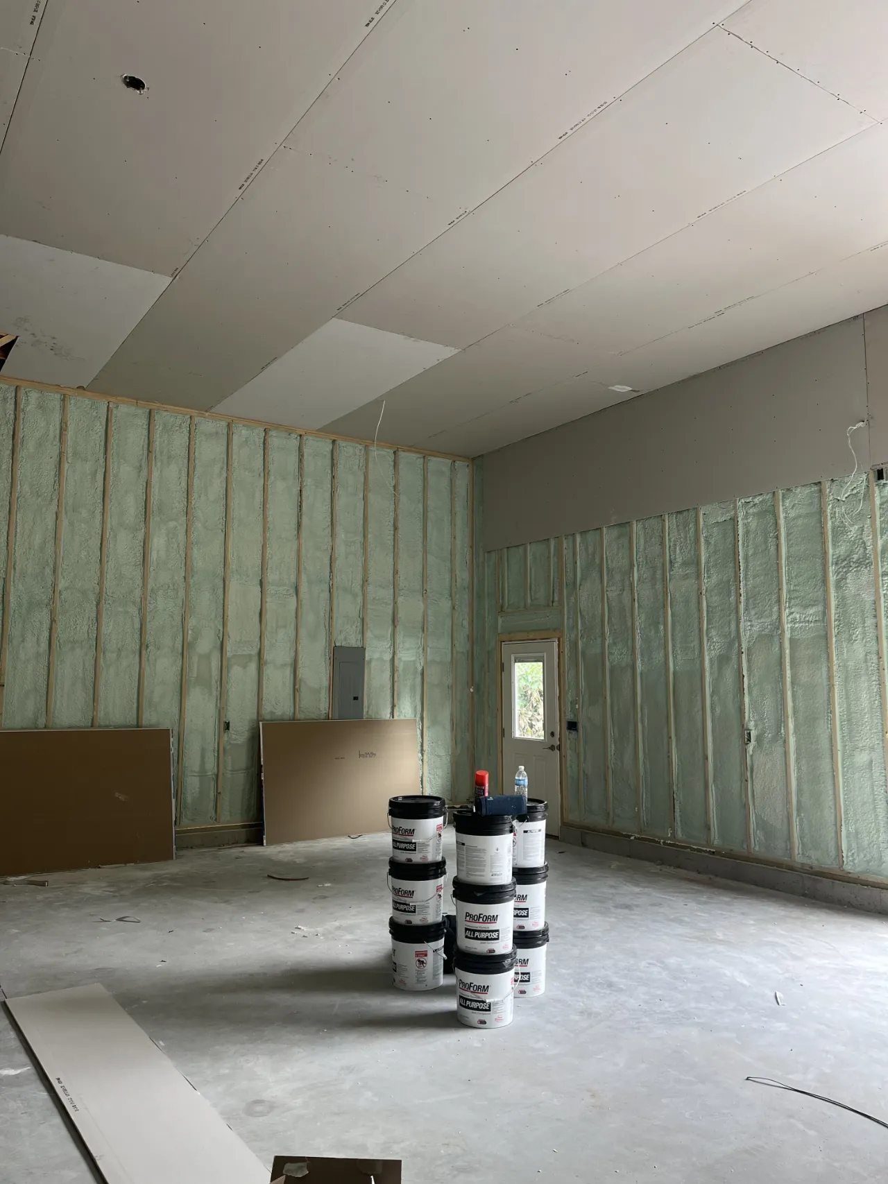 Room with drywall hung and joint compound staged for finishing in Massachusetts